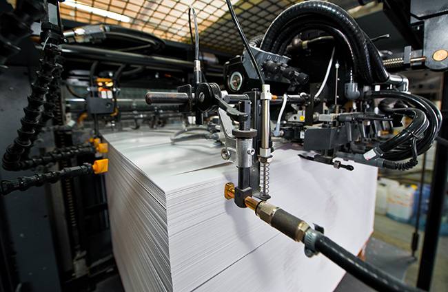 Worker operating industrial printing press