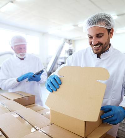 Workers in clean facility with cardboard boxes
